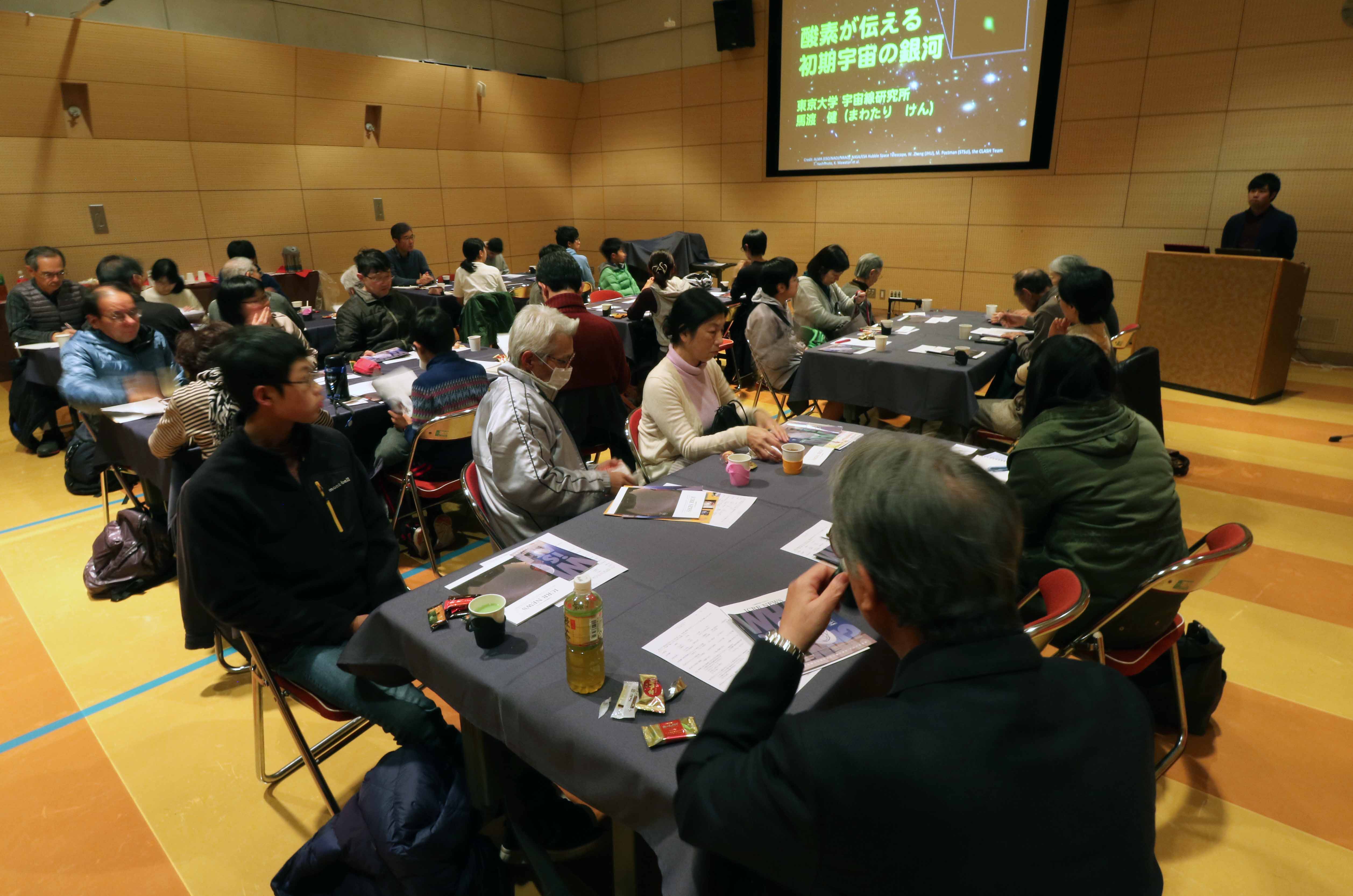 カフェに集まり、熱心に耳を傾ける34人の市民